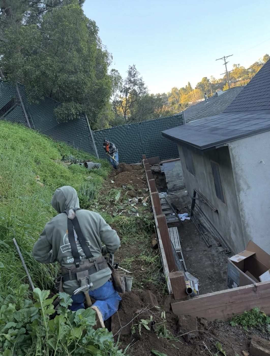 Crew digging and forming a hillside walkway