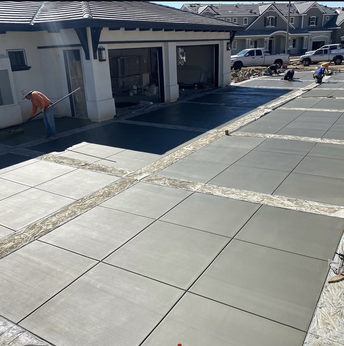 New-construction driveway with dark banded borders, broom finish